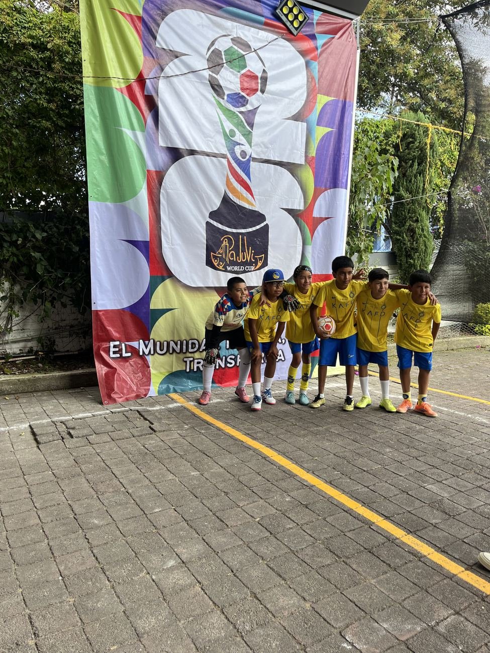 Equipo de la categoría infantil frente al banner del torneo
