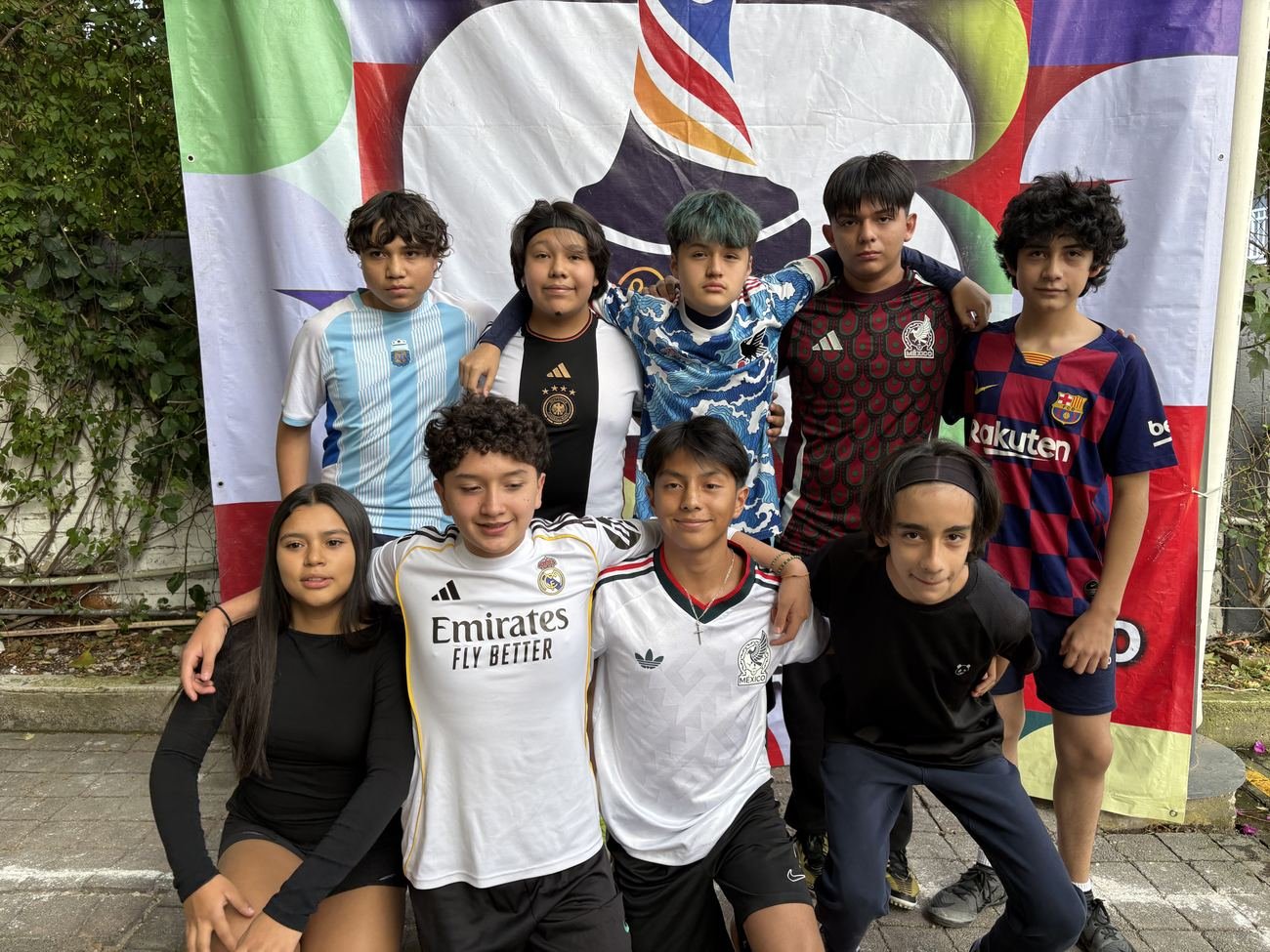 Equipo de la categoría adolescentes frente al banner